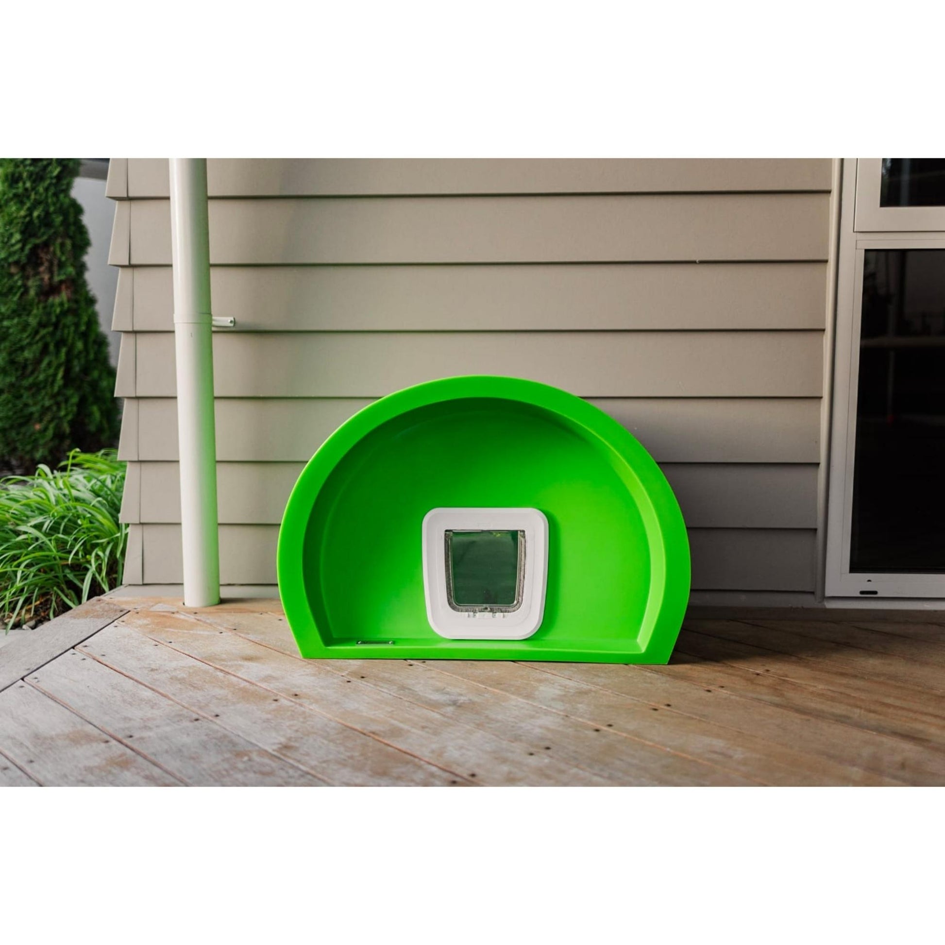 A green Modscene cat house sitting on a deck.