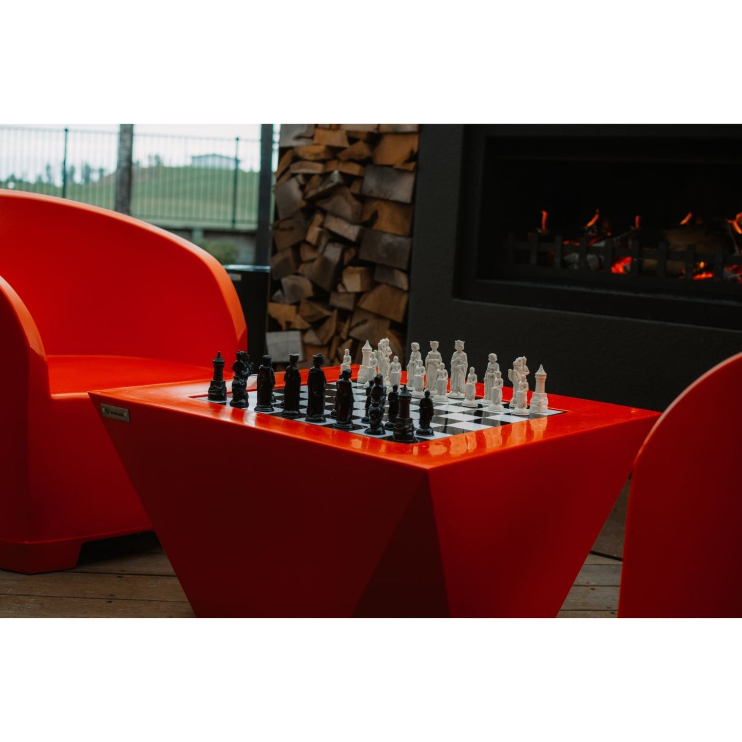 Modscene outdoor furniture on a deck with an outdoor fire in the background.