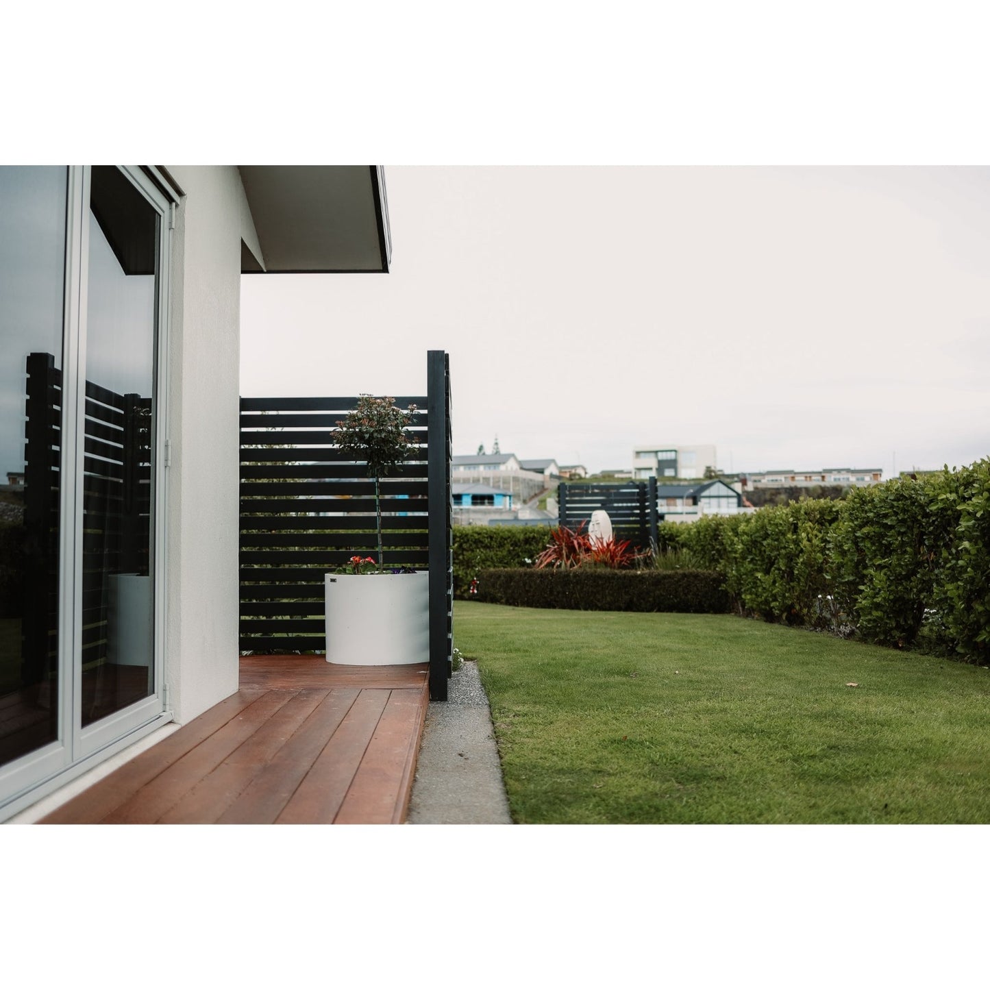 Large Ice White Cylinder planter pot on a balcony.