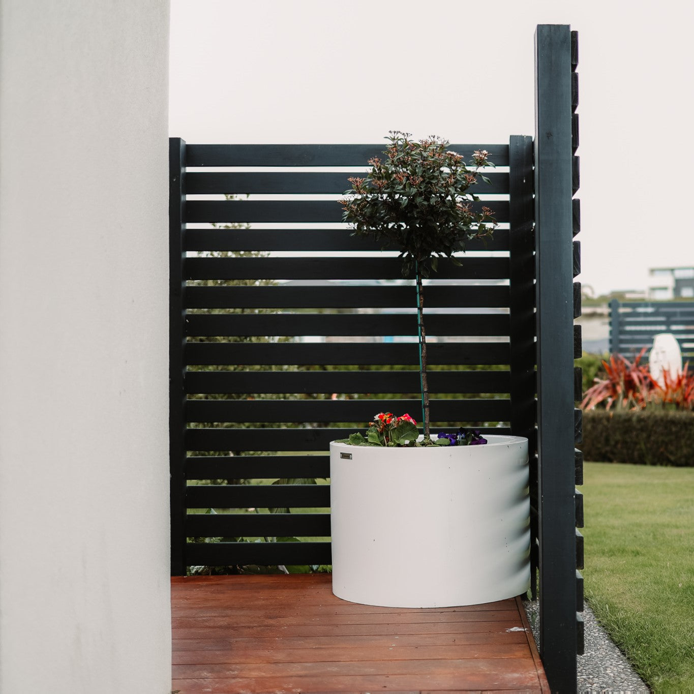Large Ice White Cylinder planter pot on a balcony.