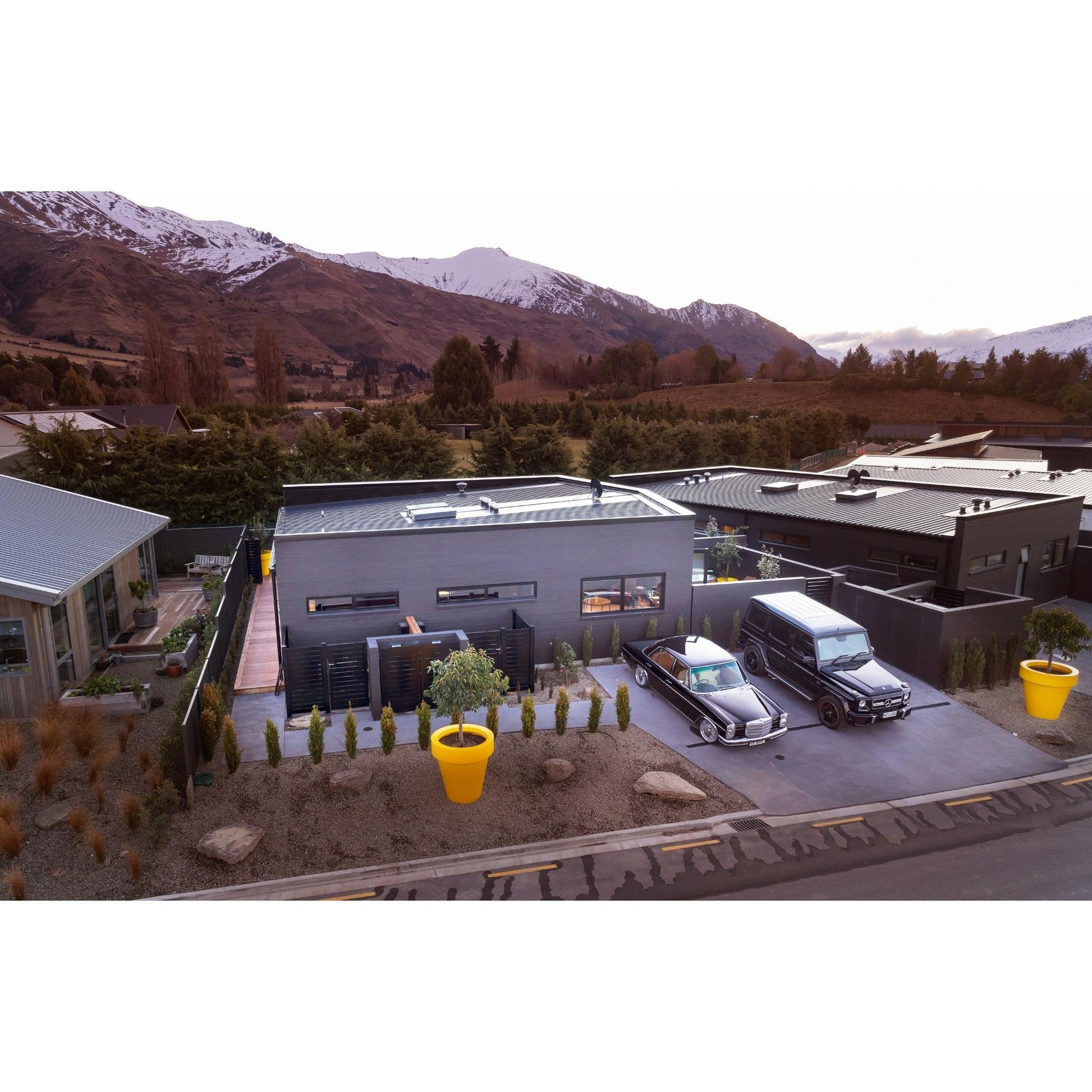 Large yellow planter pots in front of a house. Giant planter pots New Zealand.