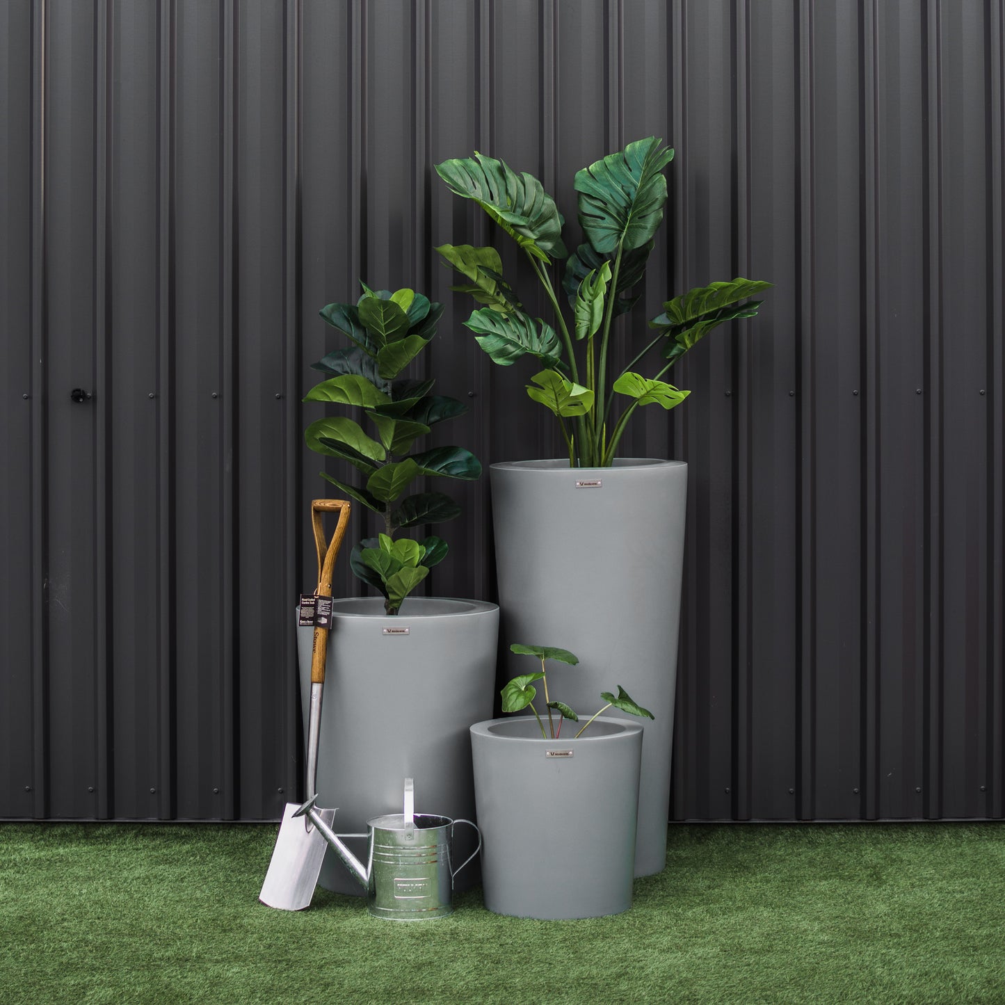 A stunning grey planter cluster in front of a black wall.