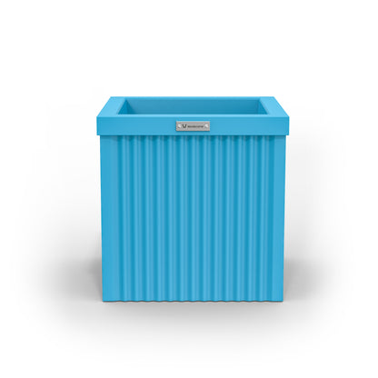 A corrugated square planter pot. The pot planter is light blue in colour.