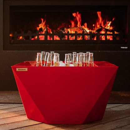 Red outdoor table in front of an outdoor fire.