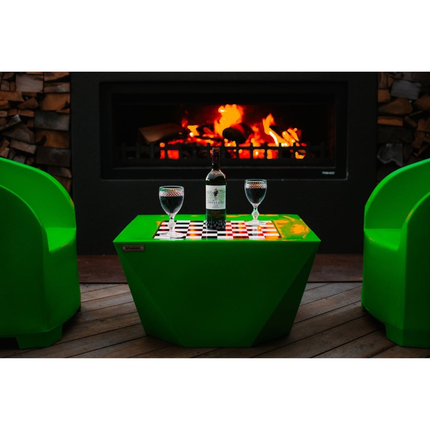 Lime green Modscene outdoor furniture on a deck with an outdoor fire in the background.
