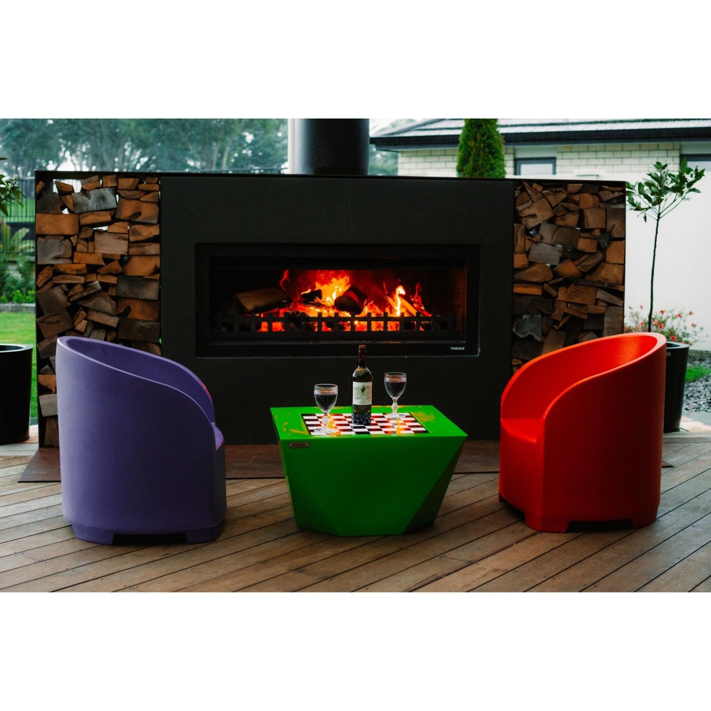 Colourful Modscene outdoor furniture on a veranda in front of a Trendz Outdoors fireplace. 