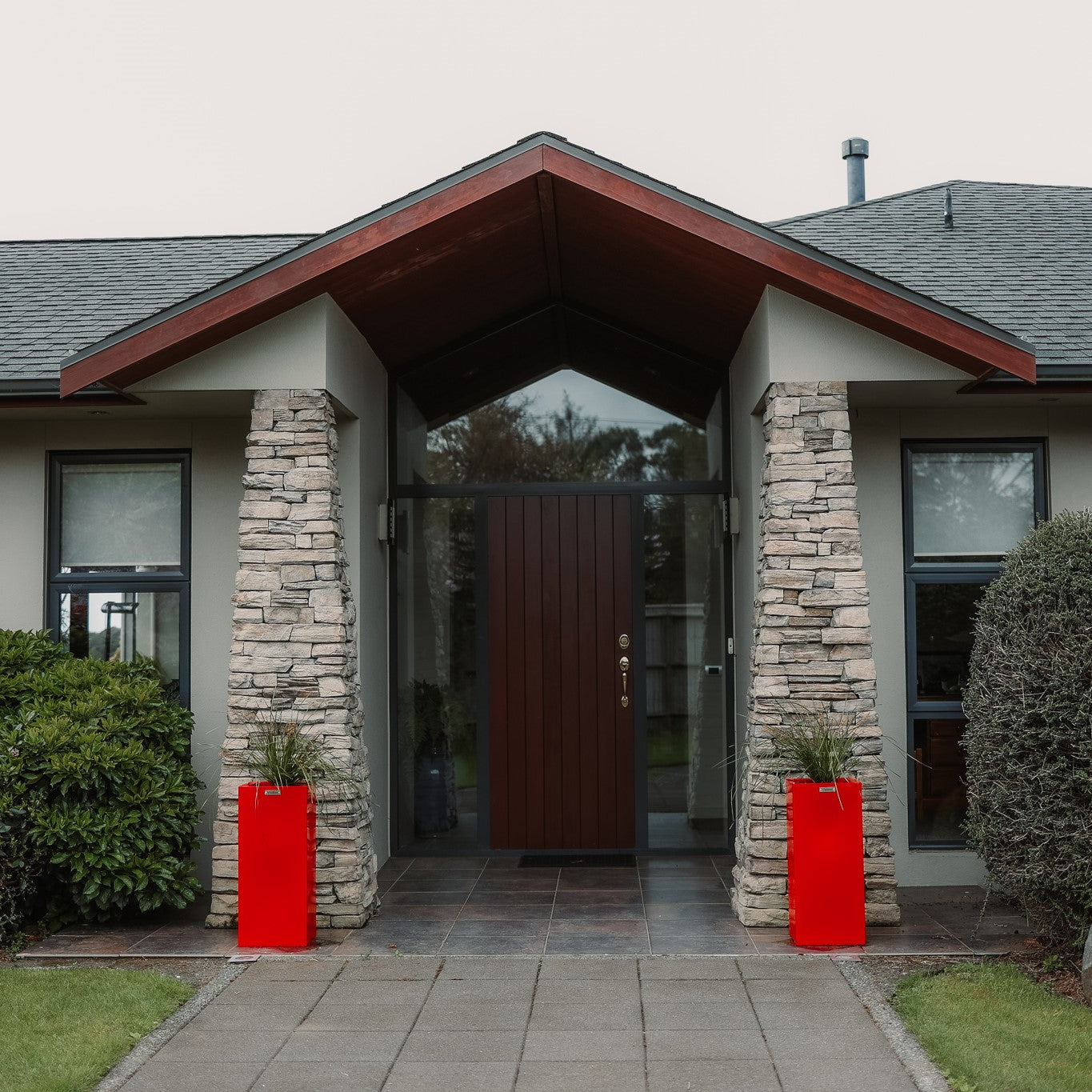 2 square red planter pots at a house entrance in New Zealand.
