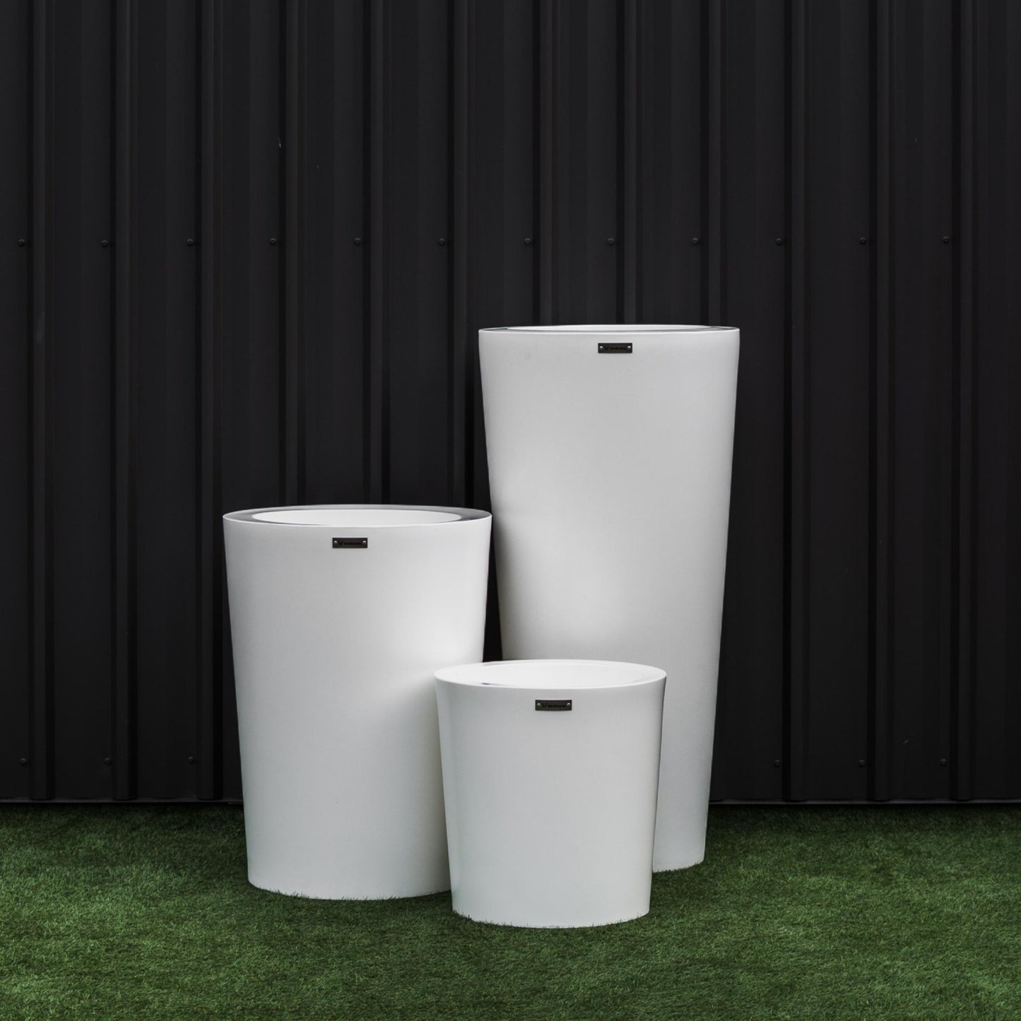 Large white NZ made planter set in front of a black wall. 