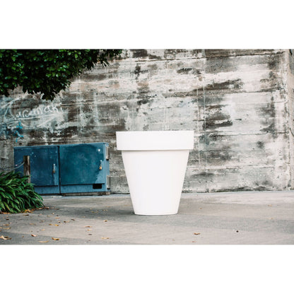 Large White planter pot in front of a wall. Giant planter pot.
