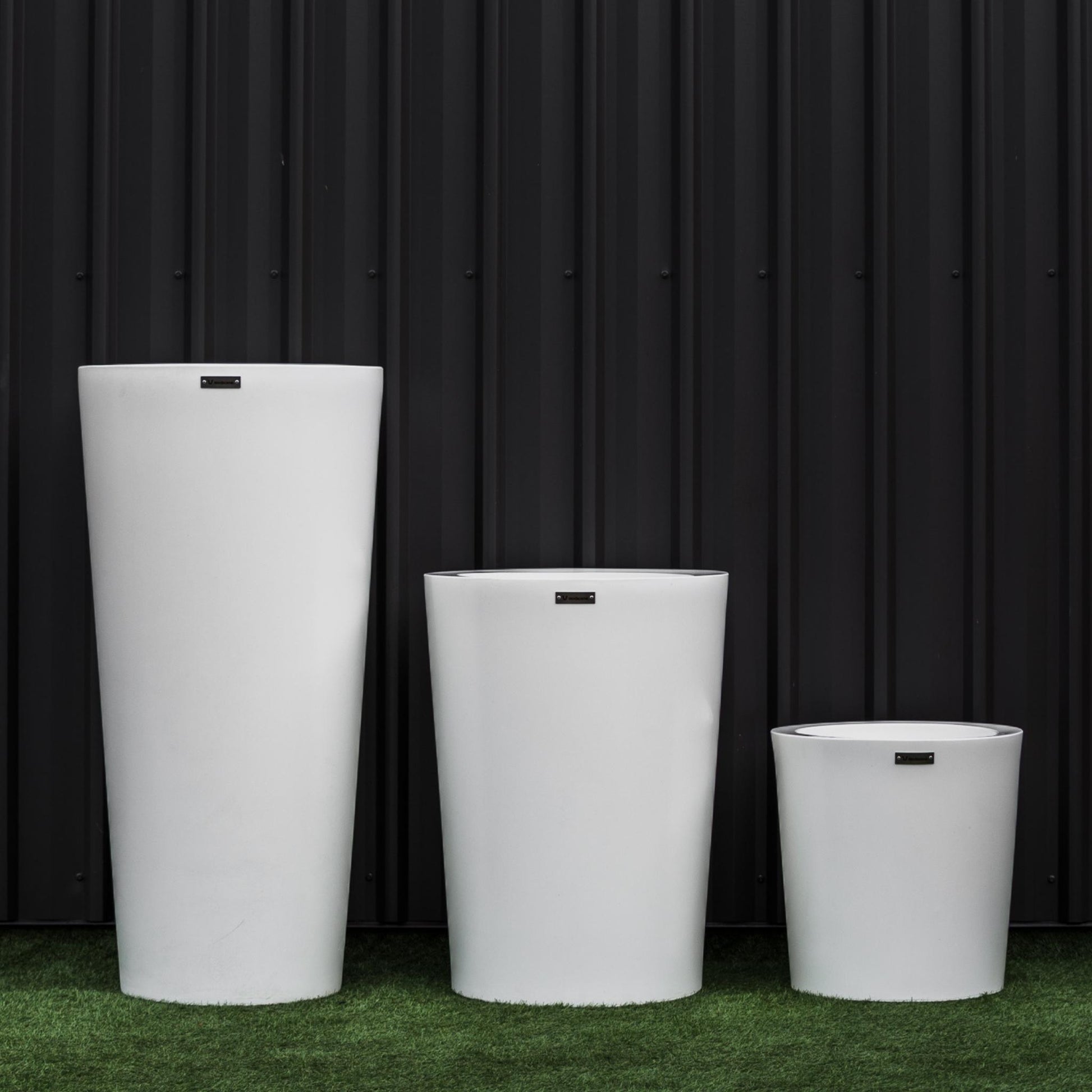 Large white NZ made planter set in front of a black wall.
