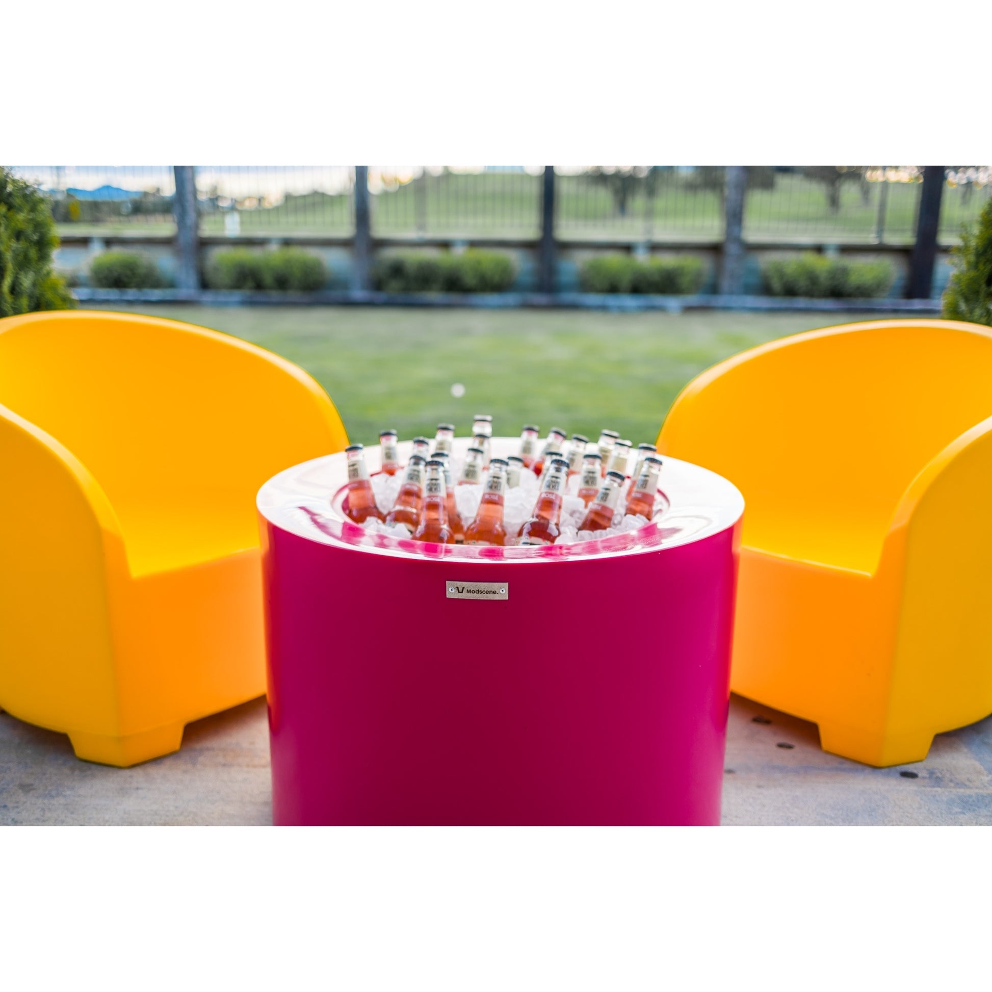 Bright pink and yellow Modscene outdoor furniture on a patio.